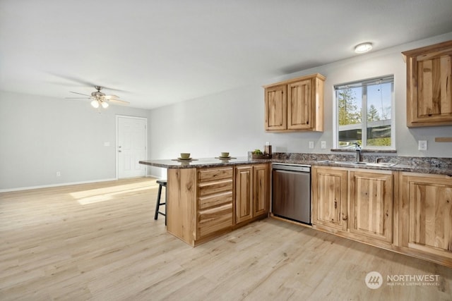 kitchen with a breakfast bar, stainless steel dishwasher, light wood-type flooring, and kitchen peninsula