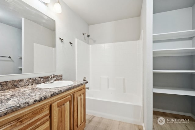 bathroom with hardwood / wood-style flooring, vanity, and bathtub / shower combination