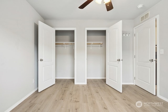 unfurnished bedroom with multiple closets, ceiling fan, and light hardwood / wood-style flooring