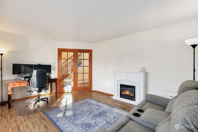 home office featuring french doors, a premium fireplace, and hardwood / wood-style flooring