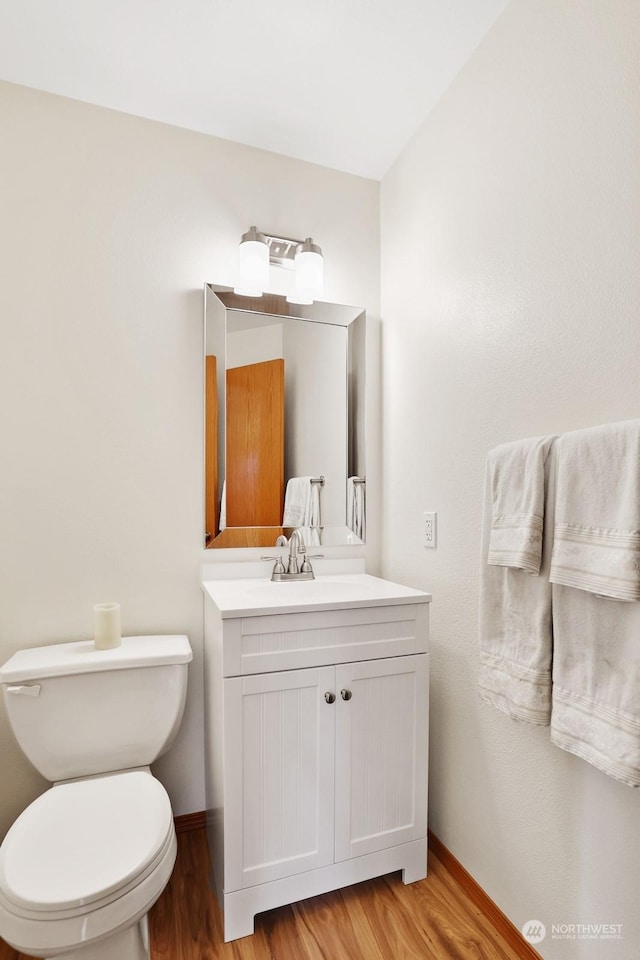 bathroom featuring hardwood / wood-style flooring, vanity, and toilet