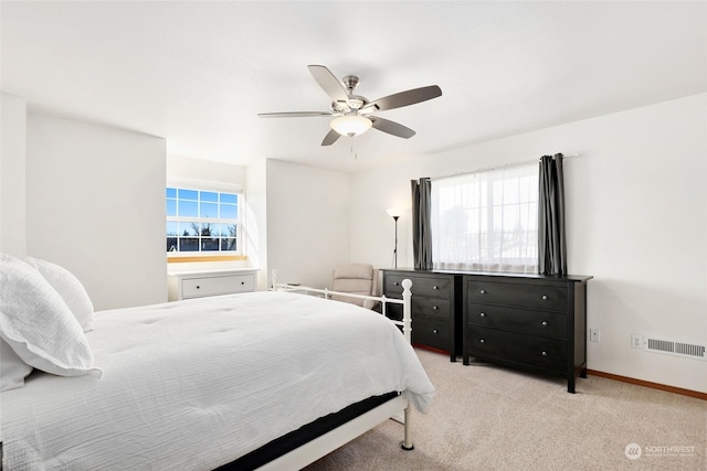 carpeted bedroom featuring multiple windows and ceiling fan