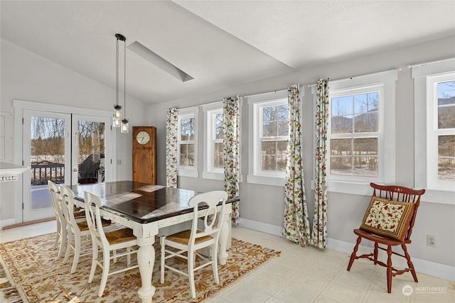 dining space featuring lofted ceiling and french doors