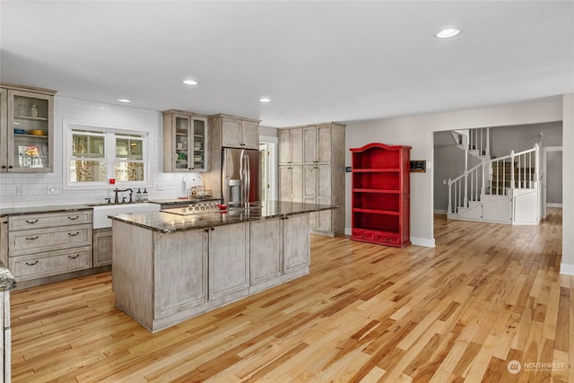 kitchen with dark stone countertops, light hardwood / wood-style flooring, and a center island