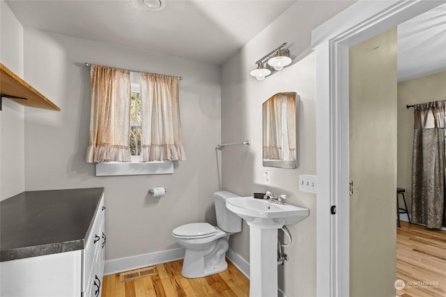 bathroom with sink, toilet, and hardwood / wood-style floors