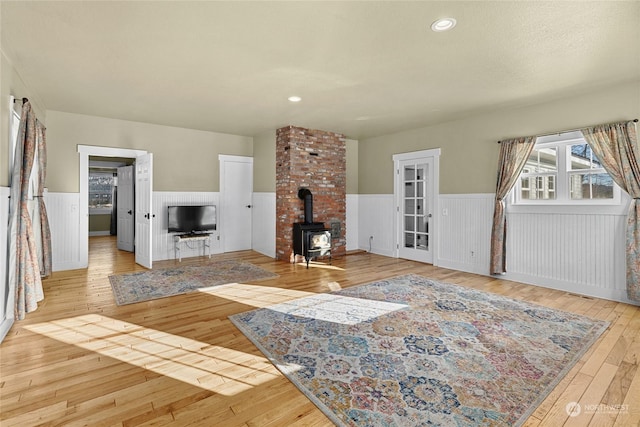 living room with a wood stove and light wood-type flooring