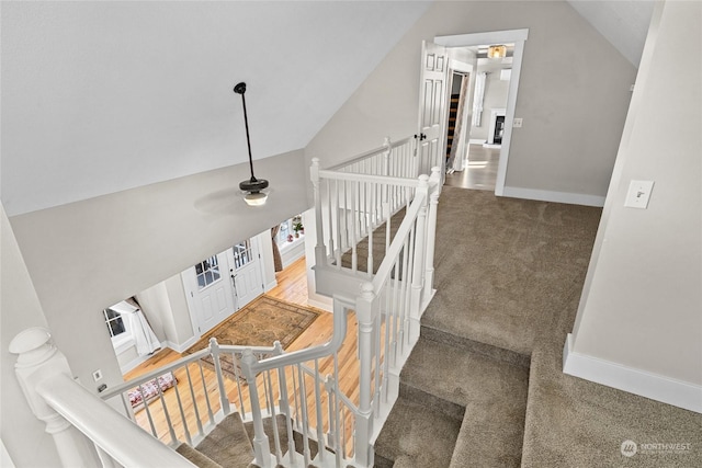 staircase with lofted ceiling, carpet floors, and ceiling fan