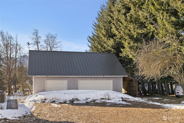 view of front of home featuring a garage and an outbuilding