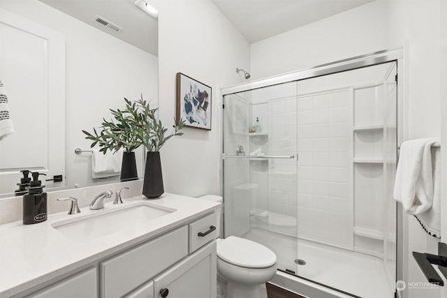 bathroom featuring toilet, vanity, and walk in shower