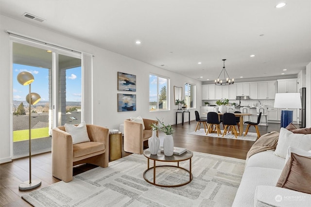 living room featuring light hardwood / wood-style floors and an inviting chandelier