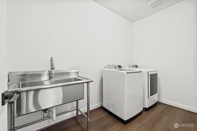 washroom with sink, dark hardwood / wood-style floors, and washing machine and dryer