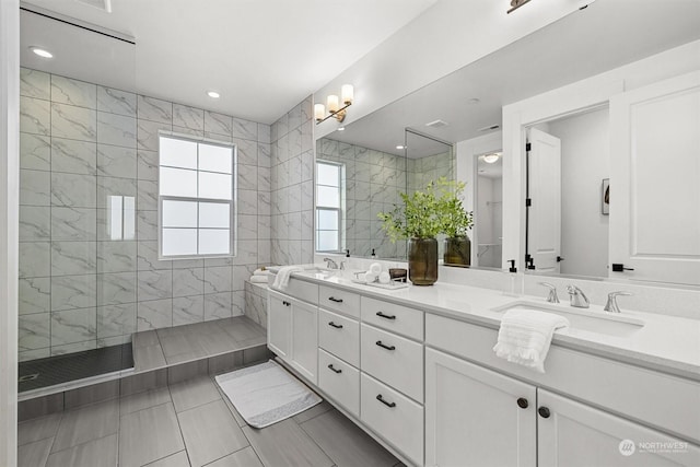 bathroom featuring tiled shower, tile patterned floors, and vanity