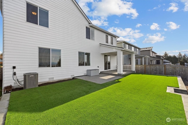 rear view of house with a patio area, a lawn, and central AC