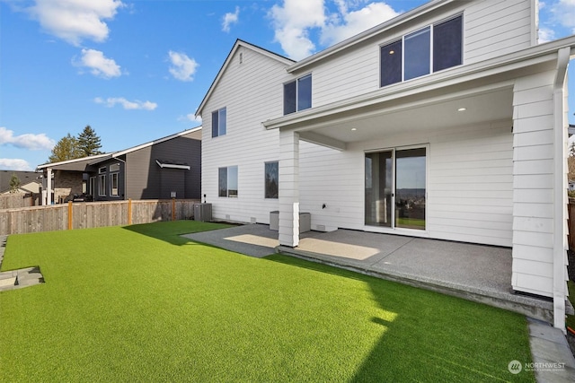 back of house with central AC unit, a patio area, and a yard