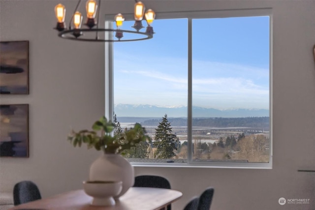 dining space featuring a mountain view and a notable chandelier