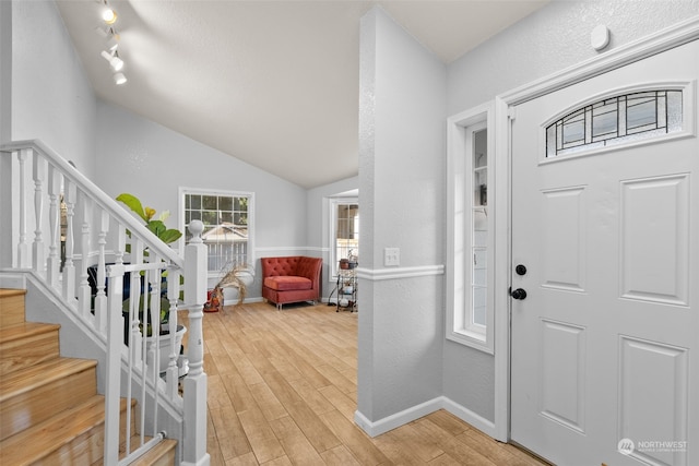 entrance foyer featuring vaulted ceiling and light hardwood / wood-style flooring