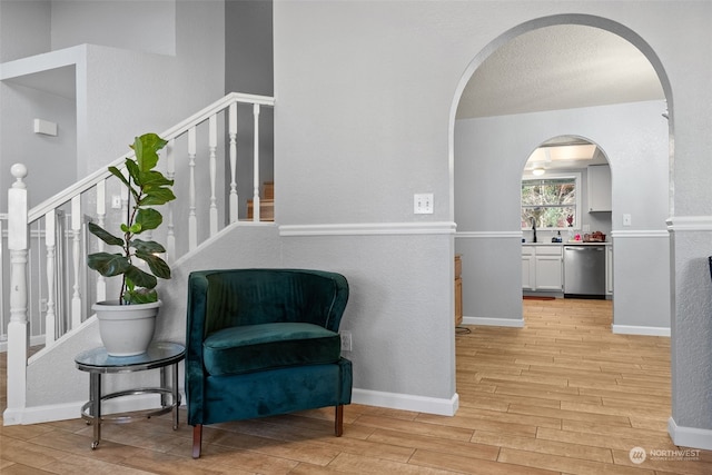 living area with sink and light wood-type flooring