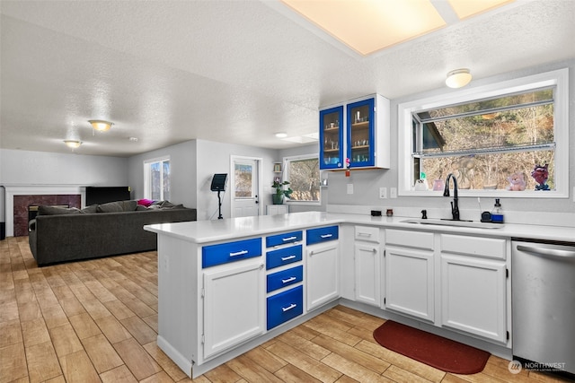 kitchen with sink, a textured ceiling, white cabinets, and dishwasher