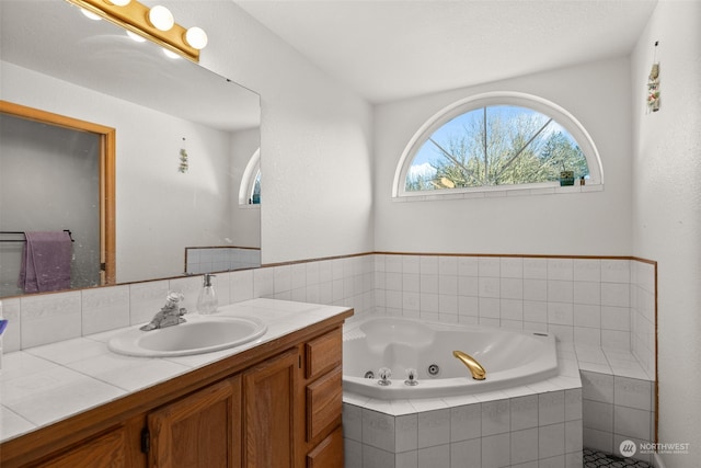 bathroom with tiled bath and vanity