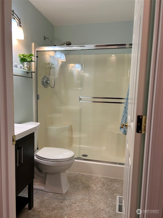 bathroom with an enclosed shower, vanity, and toilet