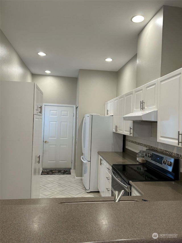 kitchen featuring electric stove, white cabinets, white fridge, and tasteful backsplash