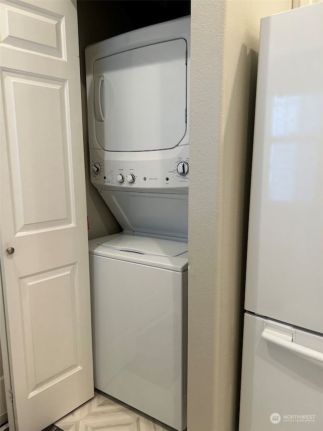 clothes washing area featuring stacked washer and dryer