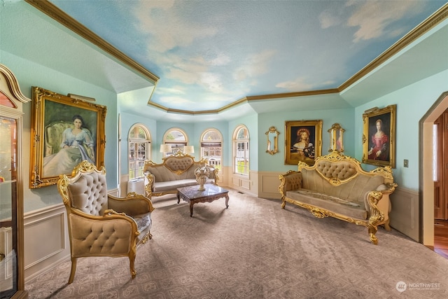 sitting room featuring a tray ceiling, carpet flooring, and crown molding