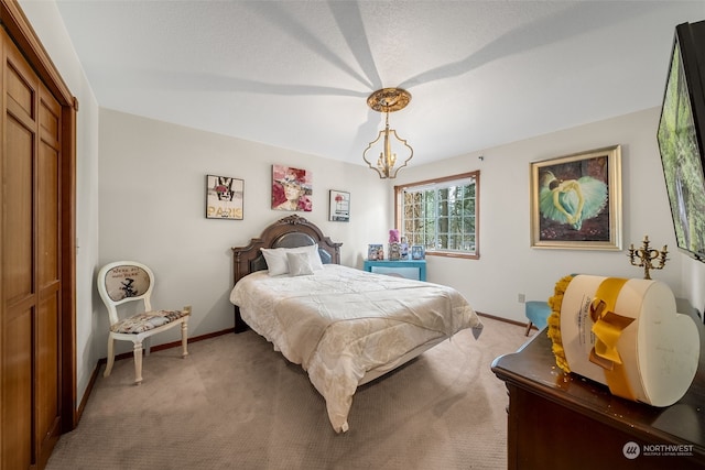 carpeted bedroom featuring an inviting chandelier