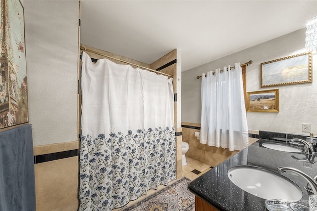 bathroom featuring tile walls, vanity, toilet, and tile patterned floors