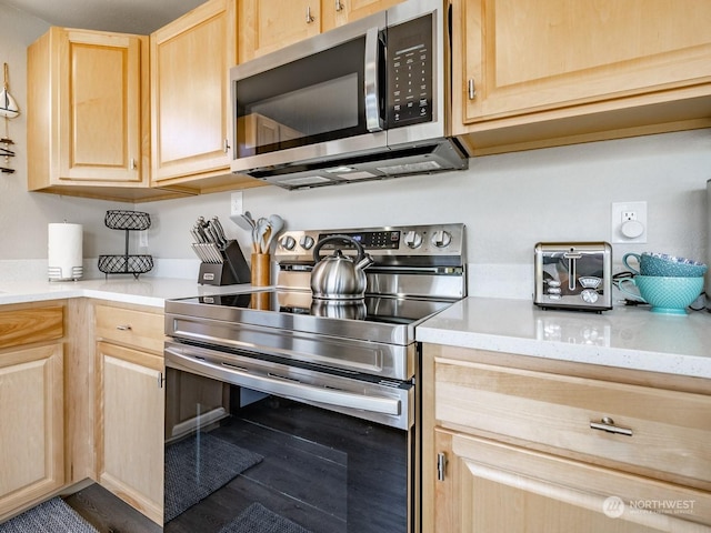 kitchen featuring light stone counters, light brown cabinets, and appliances with stainless steel finishes