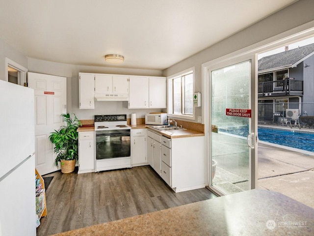 kitchen featuring hardwood / wood-style flooring, white cabinetry, sink, and white appliances