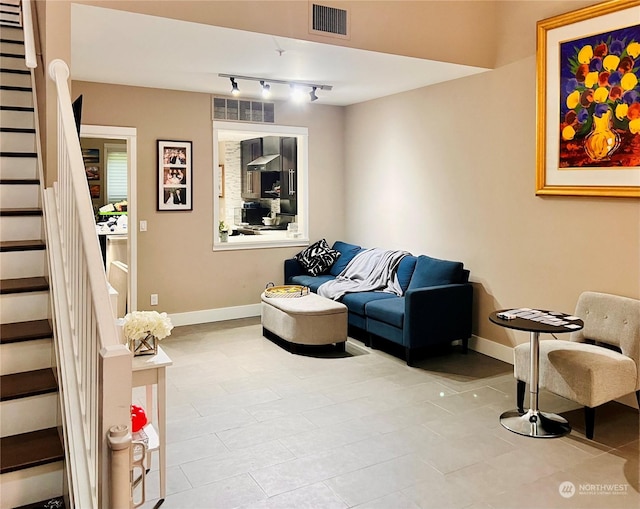 tiled living room featuring track lighting