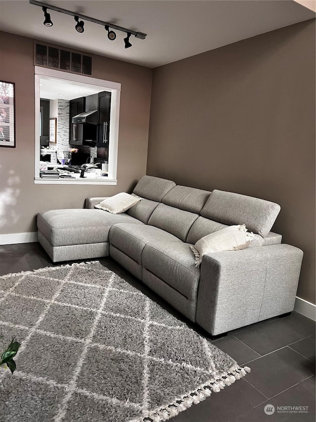 living room featuring rail lighting and dark tile patterned floors