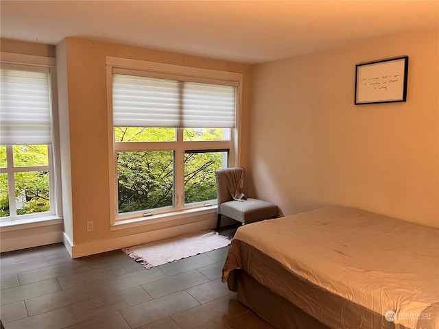 bedroom featuring dark tile patterned flooring and multiple windows