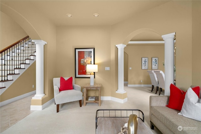 living room featuring decorative columns and light carpet