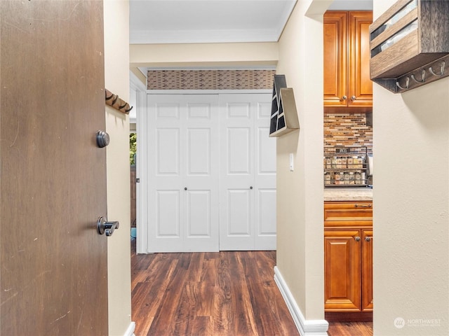 hall featuring dark wood-type flooring and ornamental molding