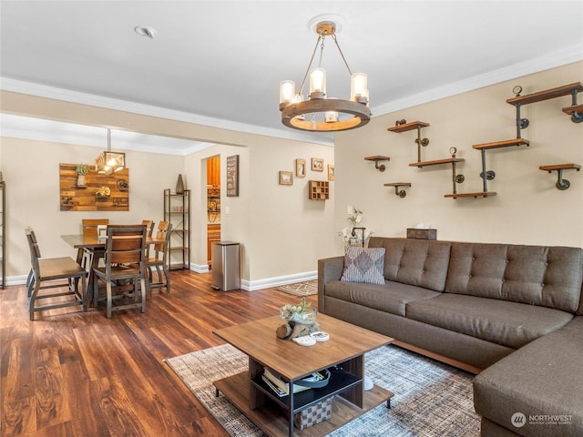 living room with dark wood-type flooring, crown molding, and a notable chandelier