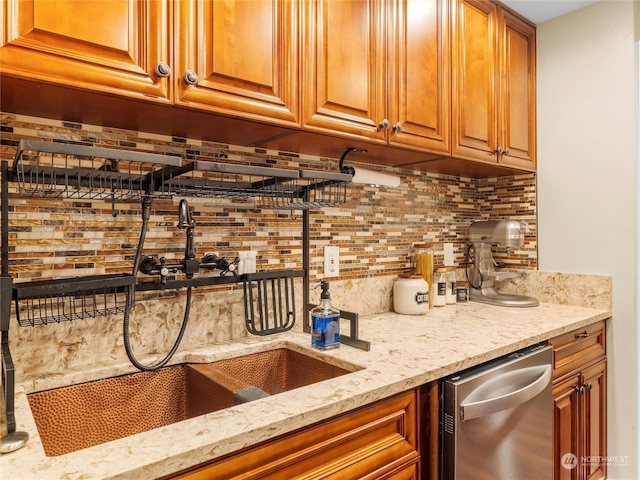 bar with sink, stainless steel dishwasher, backsplash, and light stone countertops