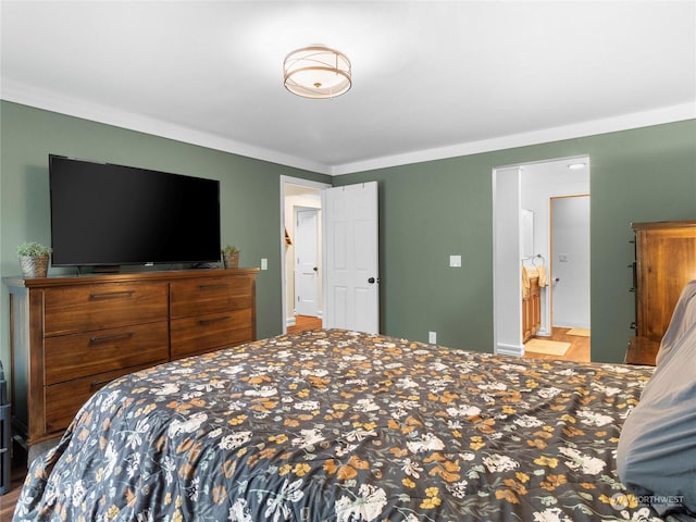 bedroom featuring connected bathroom and ornamental molding