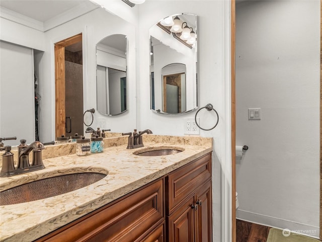 bathroom featuring hardwood / wood-style flooring, toilet, vanity, and ornamental molding