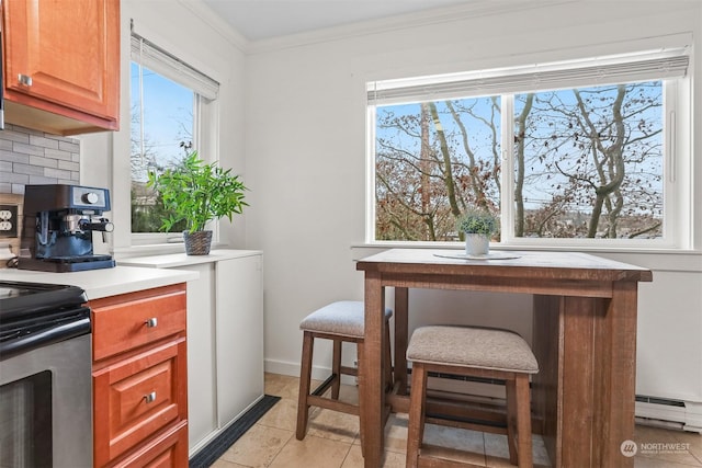 kitchen featuring a baseboard heating unit, ornamental molding, light tile patterned flooring, decorative backsplash, and stainless steel range with electric cooktop