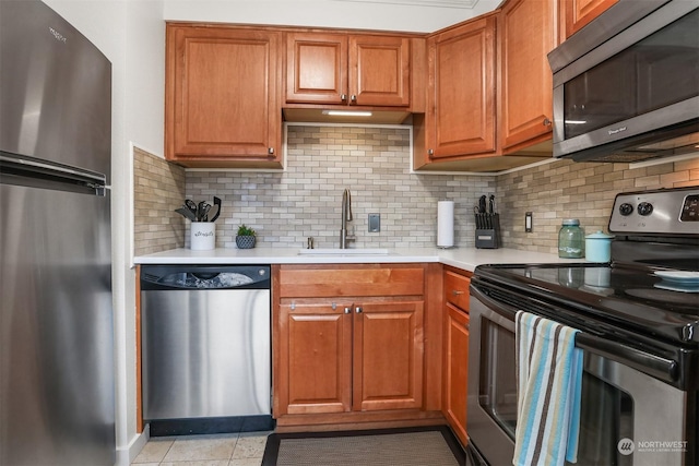 kitchen featuring sink, backsplash, stainless steel appliances, and light tile patterned flooring