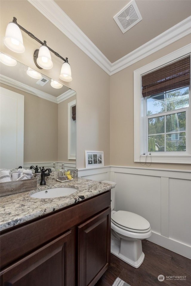 bathroom featuring crown molding, visible vents, and wainscoting