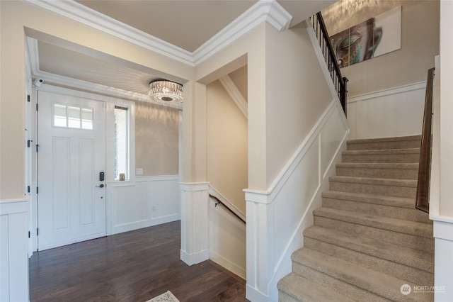 entryway with dark wood-style floors, a wainscoted wall, stairway, and ornamental molding