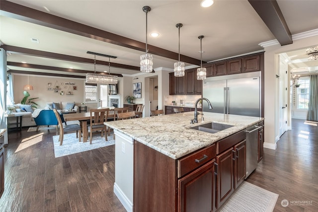 kitchen with beamed ceiling, a sink, appliances with stainless steel finishes, crown molding, and dark wood-style flooring