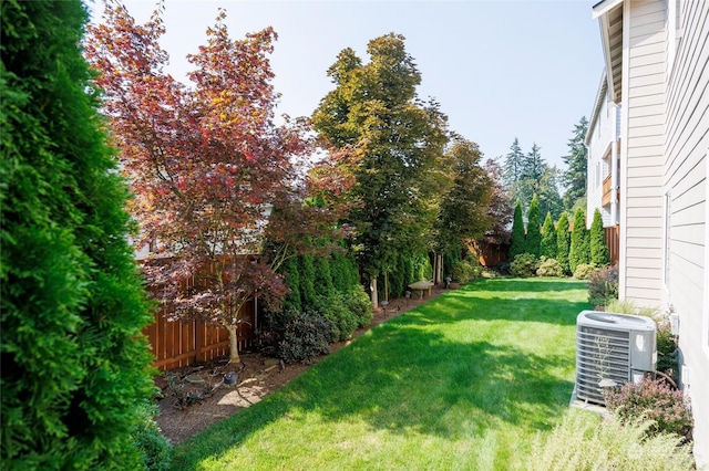 view of yard with central AC and fence