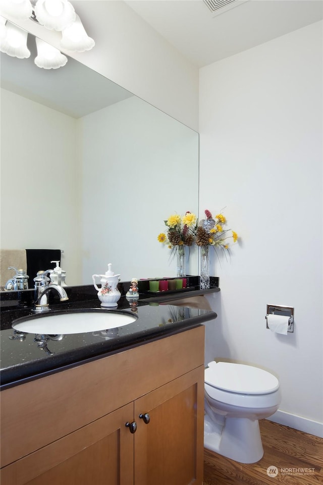 bathroom with vanity, hardwood / wood-style floors, and toilet