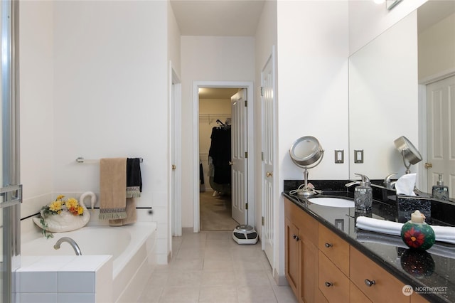 bathroom with vanity, tile patterned flooring, and tiled tub