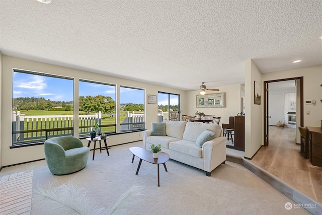 living room with ceiling fan and a textured ceiling