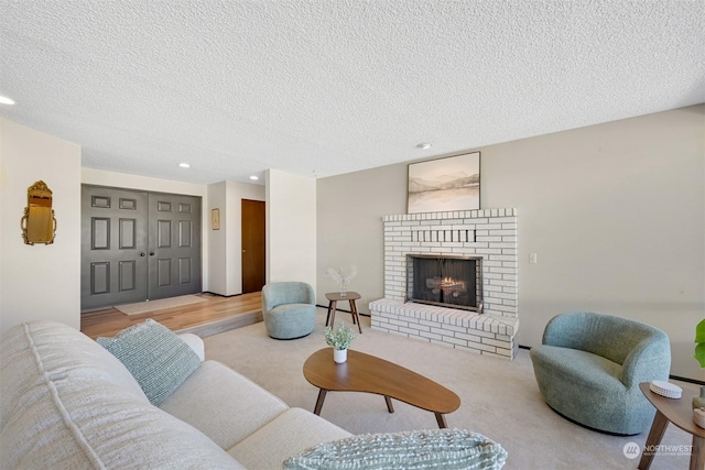 living room featuring a brick fireplace and a textured ceiling